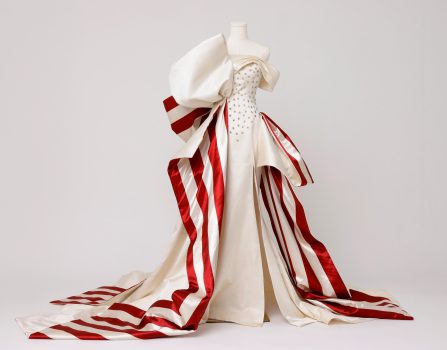 Kate Wasserbach Moore, America 250 Gown, Custom couture gown constructed in 100% duchess silk satin , designed and produced in New York City’s Garment District and hand-finished using couture construction techniques., Box for dress: 48 × 48 × 24in. (121.9 × 121.9 × 61cm) Fiberglass mannequin: 70 × 37 × 37in. (177.8 × 94 × 94cm). Glossy white round wood pedestal: 12 H × 32 diameter in. (30.5 × 81.3cm), Courtesy of the artist, New York, New York